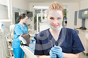 Attractive female dentist with dental tools in her hand