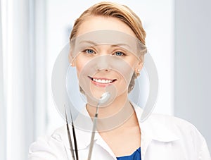 Attractive female dentist with tools