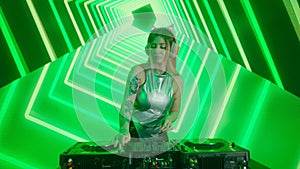 Attractive female on digital wall colorful visual graphic background. Young woman dj dancing, plays music on turntables