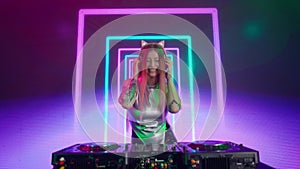 Attractive female on digital wall colorful visual graphic background. Young woman dj dancing, plays music on turntables