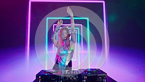 Attractive female on digital wall colorful visual graphic background. Young woman dj dancing, plays music on turntables