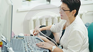 Attractive female doctor doing thyroid ultrasound.