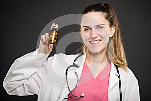Attractive female doctor holding bottle of pills