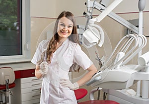 Attractive female doctor with microscope in the modern dentist office