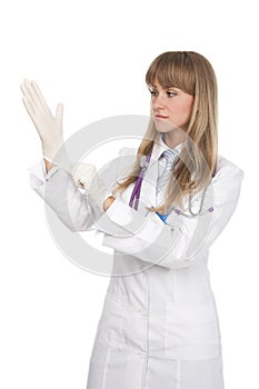 Attractive female doctor putting on surgical glove