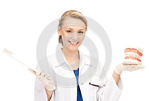 Attractive female doctor with toothbrush and jaws