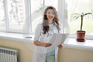 Attractive female doctor wearing a stethoscope looking at the camera with a smile