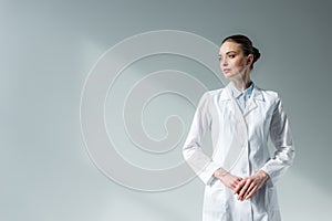 attractive female doctor in white coat looking away