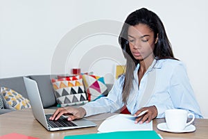 Attractive female freelancer working at home with laptop