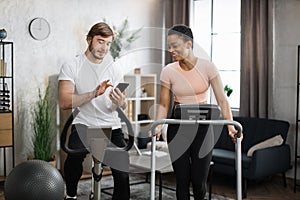 Attractive female and male working out on fitness at home.