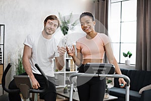 Attractive female and male working out on fitness and looking at camera.