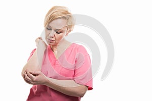 Attractive female nurse wearing pink scrubs holding elbow like h