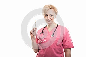 Attractive female nurse wearing pink scrubs showing diabetes shot