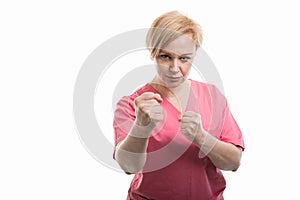 Attractive female nurse wearing pink scrubs showing fists