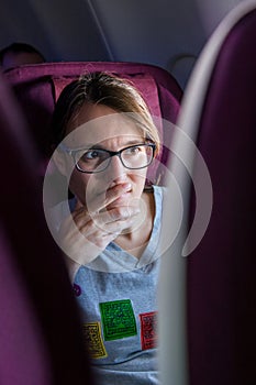 Attractive female passanger watching in-flight entertainment.