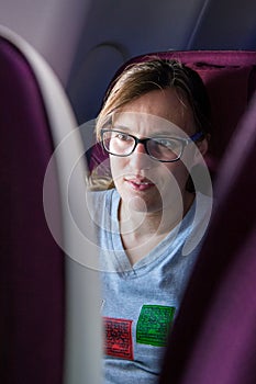 Attractive female passanger watching in-flight entertainment.