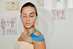 attractive female patient with kinesiological tapes