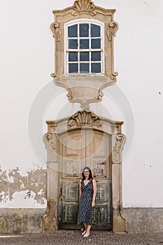 Attractive female posing against an old door in the street of Torre de Moncorvo photo