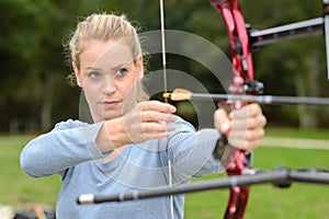 Attractive female practicing archery at range