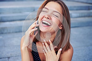 Attractive female speaking on the phone and laughing sincerely
