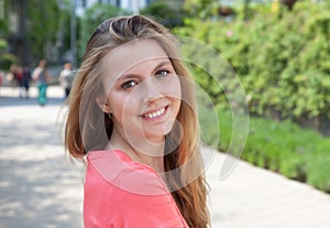 Attractive female student in a park laughing at camera