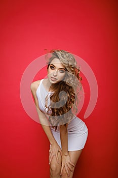 Attractive female in white sporty dress isolated on red background