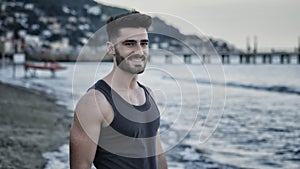 Attractive athletic young man walking on beach