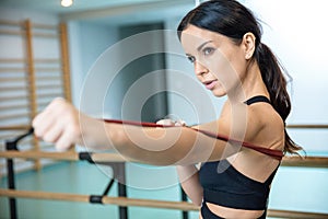 Attractive and fit brunette stretching with resistance bands