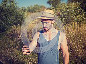 Handsome male farmer outdoor with cell phone