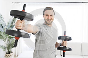 Attractive Fit man Exercise at home on the living room with dumbbell on hand