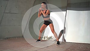Attractive fit middle age woman doing side lunges exercising outdoors