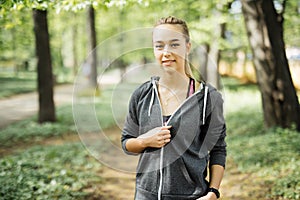 Attractive fit woman in sportswear training outdoors. Portrait of female athlete with perfect body resting after workout, fashion