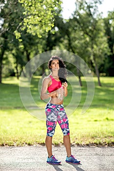 Attractive fitness athlete woman drinking water after workout exercising on sunset evening summer.