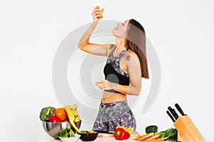 Attractive fitness woman, trained female Fit power athletic confident young woman bodybuilder eating orange, Organic Food.