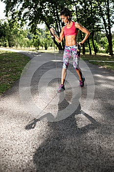 Attractive fitness young woman exercising with resistance band oudoor.