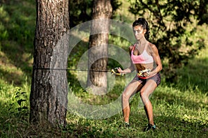 Attractive fitness young woman exercising with resistance band oudoor.