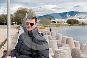 Attractive fourty year old man with sunglasses in a selfportrait at the Athens seaside