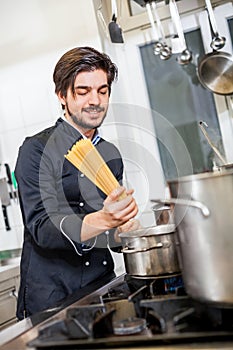 Attractive friendly chef preparing spaghetti