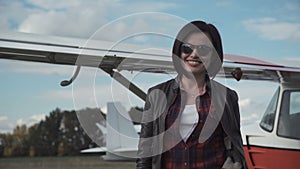 Attractive friendly woman in front of a plane