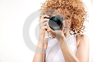 Attractive frizzy-haired lady taking a photograph