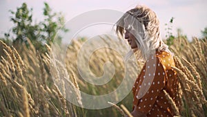 Attractive fun hippie blonde woman in the field at sunset having good time outdoors