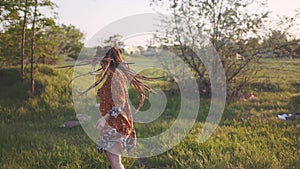 Attractive fun hippie woman with dreadlocks in the woods at sunset having good time outdoors