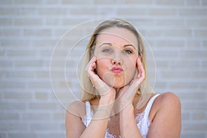 Attractive fun loving woman pursing up her lips for the camera