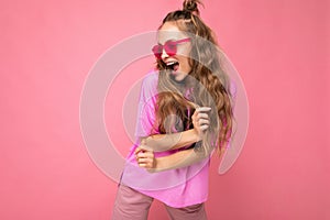 Attractive funny positive joyful young blonde woman wearing everyday stylish clothes and modern sunglasses isolated on