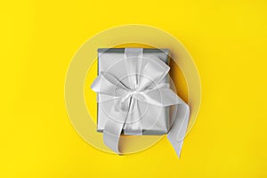 Attractive gift on the yellow background.