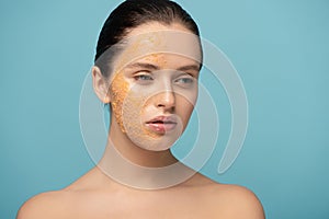 Attractive girl applying yellow sugar exfoliant