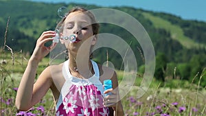 Attractive girl blowing soap bubbles