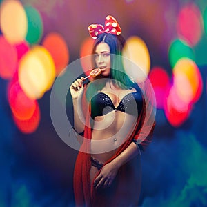 Attractive girl in colorful light party with lolly