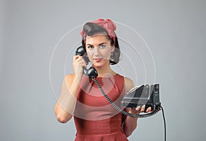 Attractive girl in a coral dress emotionally talking on the phone