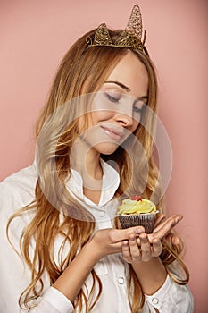 Attractive girl with a crown and cupcake